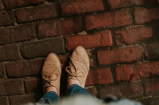 Top view of casual shoes on a brick sidewalk, perfect for illustrating urban lifestyles, fashion blogs, casual walk settings, and outdoor activities.