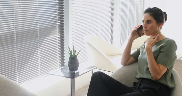 Young professional woman making phone call in modern office - Download Free Stock Images Pikwizard.com