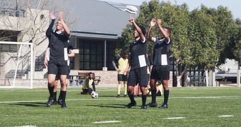 Soccer Team Celebrating Victory on Field with Enthusiasm