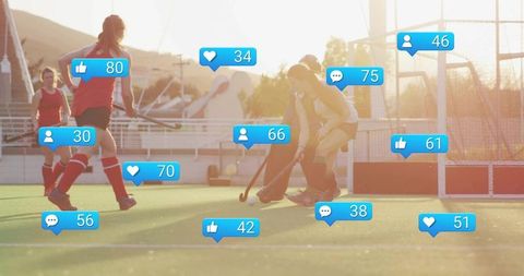 Teenage field hockey players vying for ball on sunlit turf with social media like icons
