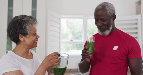 Senior Couple Enjoying Green Smoothies in Bright Kitchen