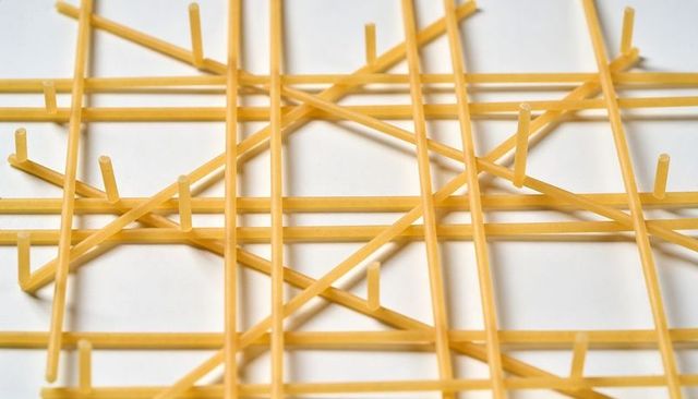 Golden spaghetti lattice creating abstract geometric pattern topdown closeup