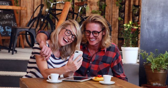 Happy Couple Enjoying Coffee and Laughing at Smartphone Screen in Cafe - Download Free Stock Images Pikwizard.com