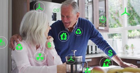 Senior couple embracing sustainable living in sunlit kitchen with green energy savings icons