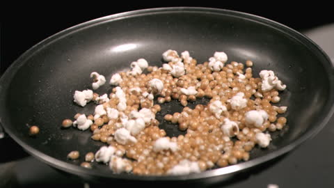 Corn Popping to Popcorn in Slow Motion on Pan
