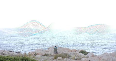 Person observing ocean waves with ethereal wave overlay at rocky shore
