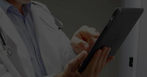 Senior Doctor Using Tablet Device in Medical Facility