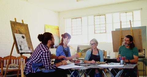 Aspiring Artists Sharing Ideas in Vibrant Studio Setting - Download Free Stock Images Pikwizard.com