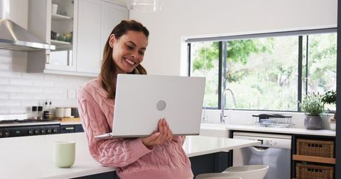 Happy Woman Working from Home in Modern Kitchen