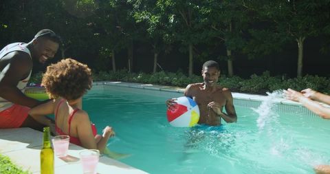 Friends enjoying vibrant pool party with beach ball and drinks