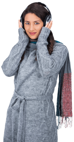 Smiling woman wearing winter clothes listening to music on headphones