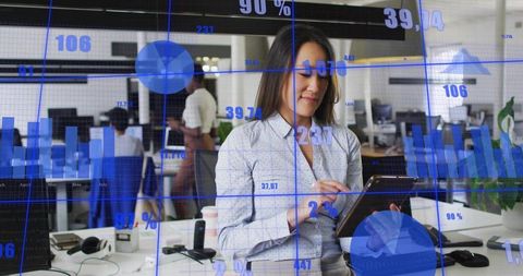 Businesswoman Analyzing Data on Tablet with Digital Analytics Overlay in Open-Plan Office