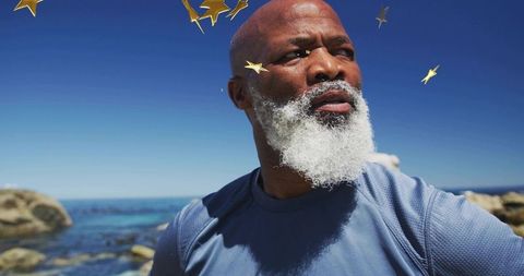 Man with White Beard Exploring Rocky Shore under Starry Embellishments