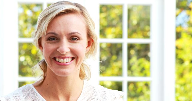 Smiling Woman Standing in Front of Sunny Window - Download Free Stock Images Pikwizard.com