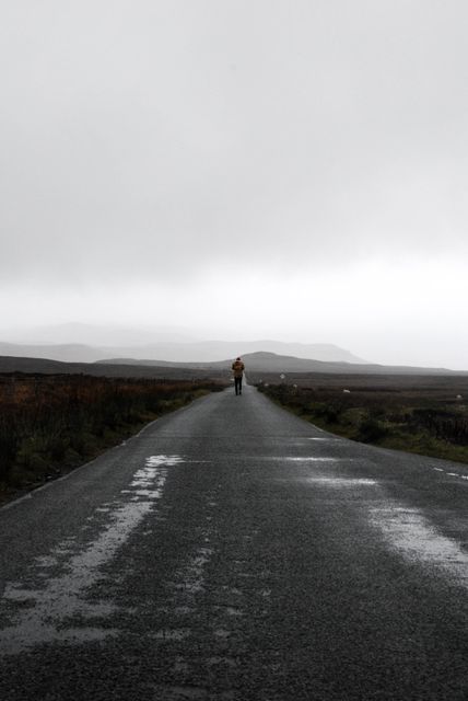 Person Walking on Desolate Road in Rainy Weather - Download Free Stock Photos Pikwizard.com
