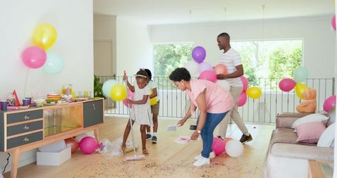 African American Family Cleaning Up After Celebration Together