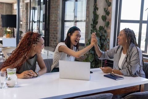 Diverse Female Team Celebrating Success in Office Workspace