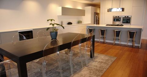 Modern Open Kitchen with Acrylic Chairs and Hardwood Floors