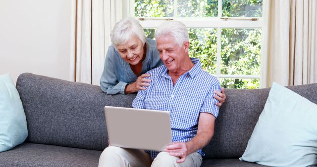 Senior couple on laptop in sitting room - Download Free Stock Photos Pikwizard.com
