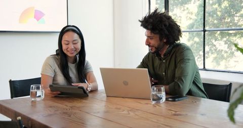 Diverse Professionals Discussing Work with Technology in Modern Office