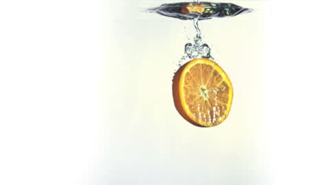 Orange Slice Submerging in Clear Water with Splash