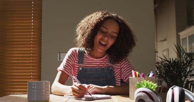 Teenager girl doing homework at home with focus on writing - Download Free Stock Images Pikwizard.com