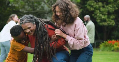 Diverse family laughing together outdoors in bright garden
