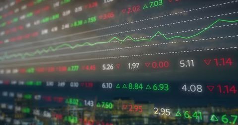 Stock market data displayed against blurred cityscape