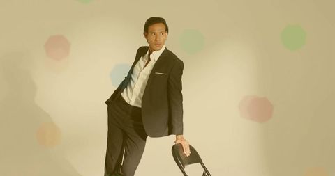 Stylish Man in Black Suit with Folding Chair, Studio Concept