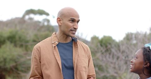 Man Talking with African American Girl Outdoors in Casual Jacket and Headband