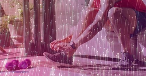 Tying running shoe before workout in sunlit home gym with smartwatch and purple dumbbells