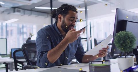 Speaking on Phone While Reading Document at Modern Open-Plan Office Desk