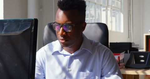 Focused Young Businessman Working on Desktop in Modern Office