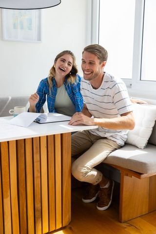 Smiling Couple at Home Reviewing Documents Together