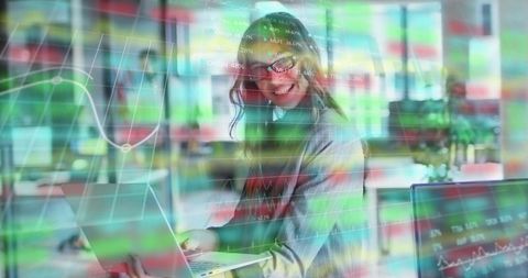 Businesswoman Analyzing Data with Futuristic Financial Graphs in Modern Office