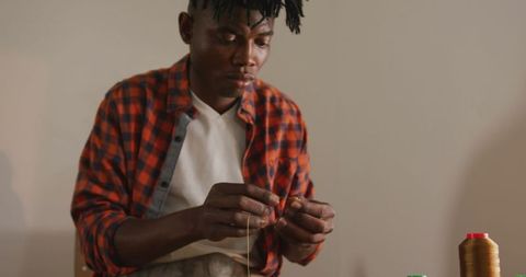 African American Craftsman Threading Needle in Artisan Workshop