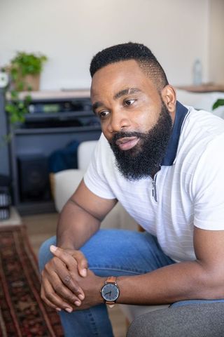 Thoughtful Man Relaxing on Sofa in Modern Living Room