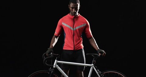 Professional Cyclist Holding Bike on Minimalist Dark Backdrop