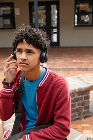 Teen Listening Music Using Headphones and Smartwatch at School
