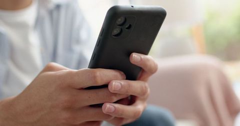 Focused Young Adult Holding Smartphone in Comfortable Home Setting - Download Free Stock Images Pikwizard.com
