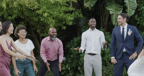 Guests joyfully celebrating outdoors at wedding reception