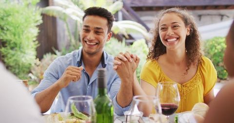 Laughing Couple Enjoys Outdoor Patio Dinner with Friends
