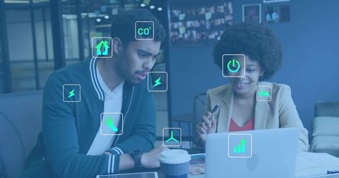 Collaborating on clean energy dashboard with sustainability icons in modern office
