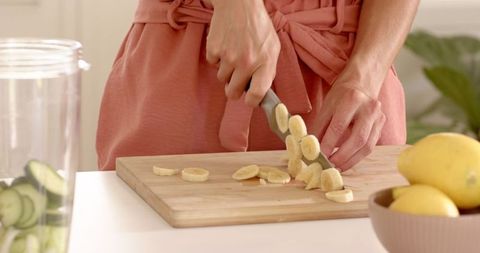 Woman Slicing Banana for Homemade Cuisine with Fresh Lemons