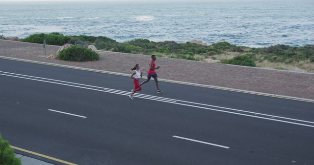 Two People Running on Coastal Road Near Ocean - Download Free Stock Images Pikwizard.com