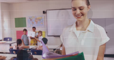 Smiling Teacher Engaging with Classroom While Reviewing Documents