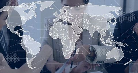 Business team collaborating over documents with global map and hexagon network overlay