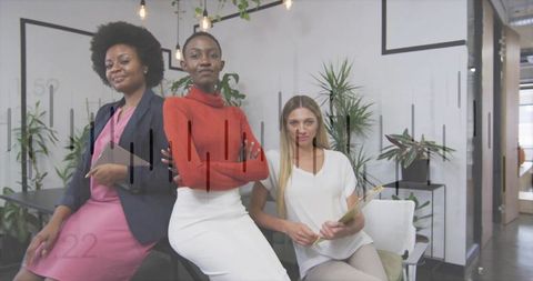 Confident women posing in modern minimalist office holding tablet and clipboard