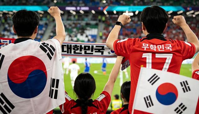 South korean fans cheering and waving flags while holding scarf in packed stadium