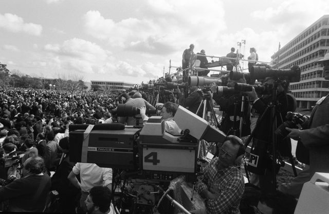 S86-26428 (31 Jan. 1986) --- Dozens of cameras and thousands of eyes focus on President Ronald Reagan (out of frame at left) during the 51-L memorial services Jan. 31 on the mall at the Johnson Space Center (JSC). The photograph was taken from special bleachers quickly erected to accommodate hundreds of members of the news media. The audience of thousands was largely made up of JSC employees and family and friends of the Challenger crew members who perished four days earlier in the attempted launch of NASA’s 25th STS mission. Photo credit: NASA
